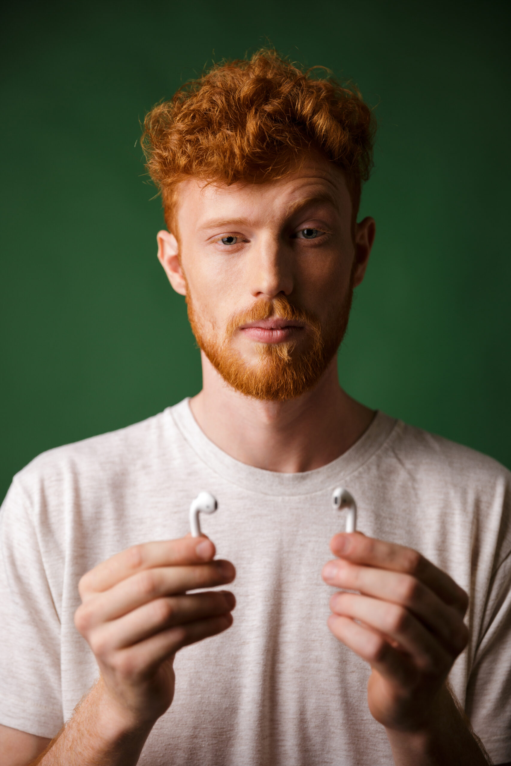 Close-up portrait of curly redhead man with raised eyebrow, show